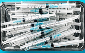 A tray of needles sits against a blue surface.