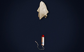 A tissue hovers above a tampon with blood on the tip against a dark blue background.