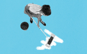 A person scrubbing a stain on the ground with a mop and bucket.