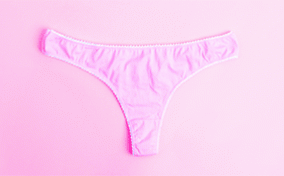 Pink panties on a pink background with red droplets.