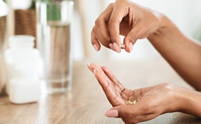 A woman's hands holding vitamins that help with vaginal dryness.