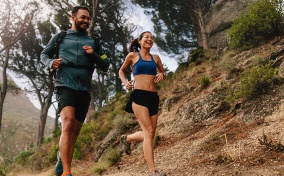 A-man-and-a-woman-running-on-an-outdoor-mountain-trail
