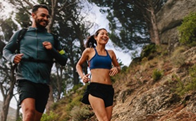 A-man-and-a-woman-running-on-an-outdoor-mountain-trail