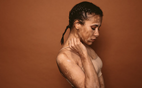 A-woman-stands-turned-to-the-side-while-deep-in-thought