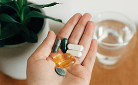 A-hand-is-holding-different-kinds-of-pills