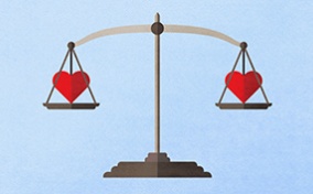 A scale weighs two red hearts, one on each side. 