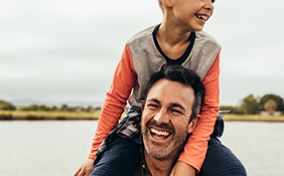 A-child-sits-on-hist-dads-shoulders-and-both-laugh