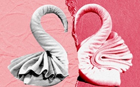 Two towels formed into half a heart break apart against a multi-shaded pink background.