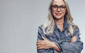 Grey-haired-woman-in-glasses-crosses-her-arms
