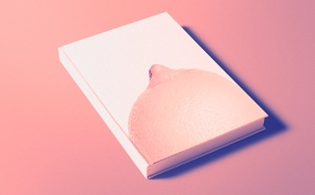 A book shows with a prosthetic breast and nipple on the cover.