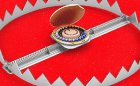 A pack of birth control sits in the middle of a rigged metal trap.