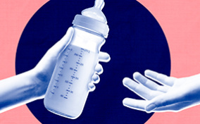 One arm is reaching out to hand a bottle of breast milk to another.