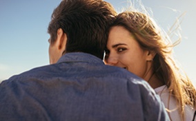 A couple sits with their backs to the camera and one of them looks back over her shoulder.