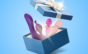 Multiple vibrators are inside a blue gift box that is popping open. 
