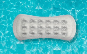 A pool floaty shaped like a menstrual pad, floats in a blue pool.
