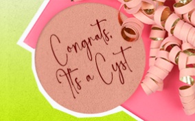 A pink gift sits against a lime green background with a tag that says congrats its a cyst.