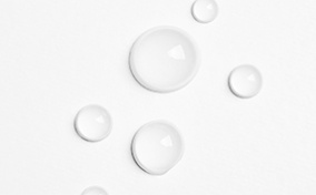Water drops are bubbled against a white surface.