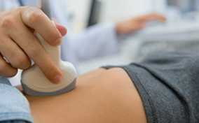 A woman is getting an ultrasound done on her pelvic region.