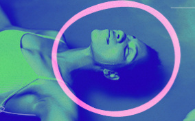 A woman floats in a sensory deprivation chamber with a pink circle around her head.