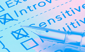 A personality test page has boxes for introvert and sensitive checked by the pen laying on top of it.