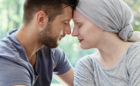 A woman touches foreheads with a man after undergoing chemotherapy for pancreatic cancer.