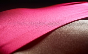 A close up photo depicts a woman's lower stomach and pink panties.