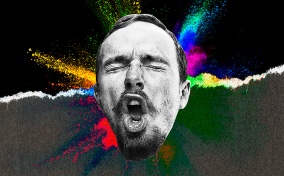 A man makes a face during an orgasm with multiple colors spraying from behind his head.