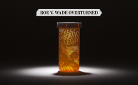 A pill bottle with an image from pro-abortion rights rally is underneath a news clipping about the overturning of Roe v Wade.