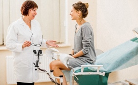 A woman sits talking to her gynecologist during her first visit alone.
