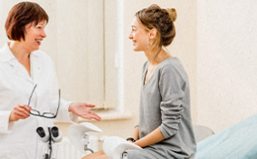 A woman sits talking to her gynecologist during her first visit alone.