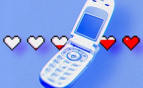 An old flip cellphone is open with a line of white hearts behind it that are filling up with red.