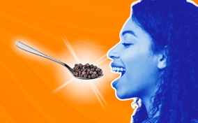 A blue woman opens her mouth for a spoon full of pepper corns.