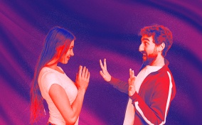 A woman looks at her partner with hands together and smiling while he looks surprised.