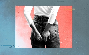 A woman in jeans holds on to her butt as she feels pain during her period.