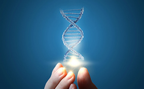 A DNA strand is lit up and held by a hand at the fingertips against a blue background.