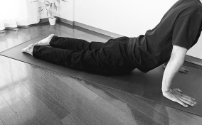 A man stretches his pelvic floor during an exercise on a yoga mat.