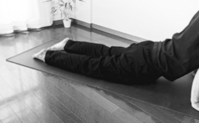 A man stretches his pelvic floor during an exercise on a yoga mat.