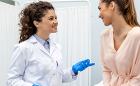 A college student talks to her OB-GYN during a routine visit.