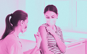 A nurse gives a woman a vaccine for COVID-19.