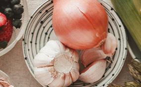 A view from above shows fruits and vegetables sit in bowls on a table.