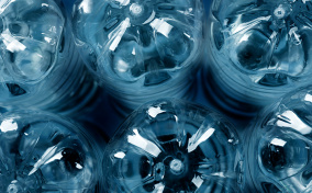 The bottom of six plastic water bottles are clustered together and tinted blue.