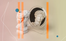 A marble bust of a head looks into a mirror and sees a cracked reflection of itself.