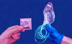 One hand holds a condom out towards another hand covered in a blue glove holding a breathing mask and tube.