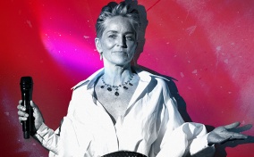 A black and white image of Sharon Stone with a mic in hand is on a pink and red background.