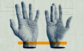 A pair of hands lay open-palmed with a yellow block layering over both wrists.