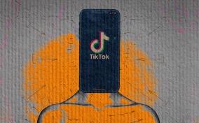 A cellphone shows the TikTok app as it sits on a body in place of a head.