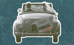 A couple drives away in a car with a Just Celibate sign on the back.