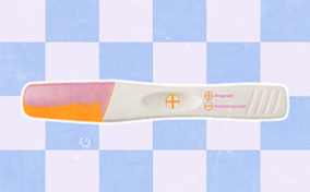 A pregnancy test shows a result of pregnant against a blue and white checkered background.