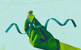 A gloved hand holds a vial of a drug for ovarian cancer as a green ribbon wraps around it.