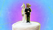 A wedding cake topper has a unicorn head and a horse head atop the bodies.